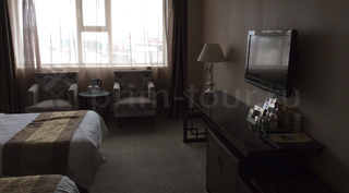 Кровать в 2-ух местном номере гостиницы Шеньбо в г. Хуньчунь.